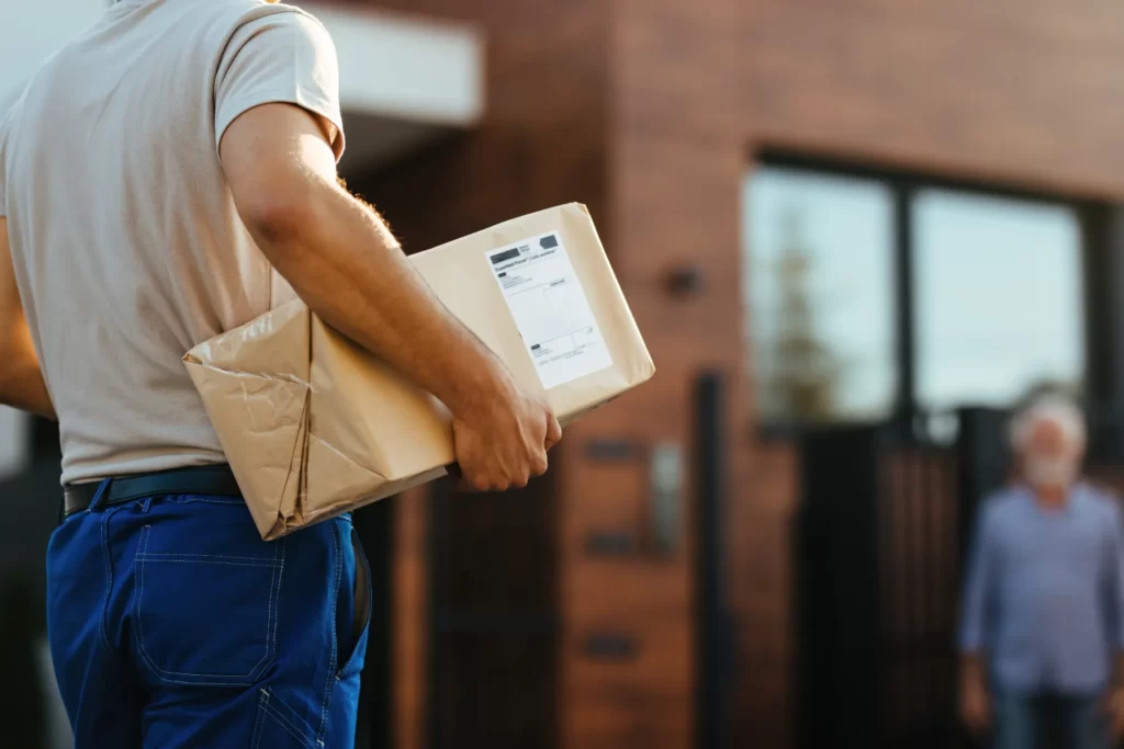 delivery person carrying package to suburban home utc